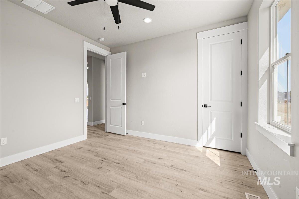 Unfurnished bedroom with light wood-style flooring, a ceiling fan, and recessed lighting