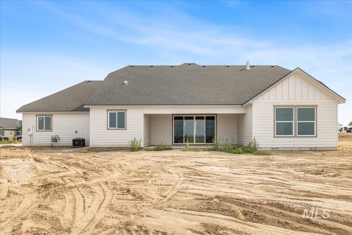 Back of house featuring roof with shingles, a patio, board and batten siding, and crawl space