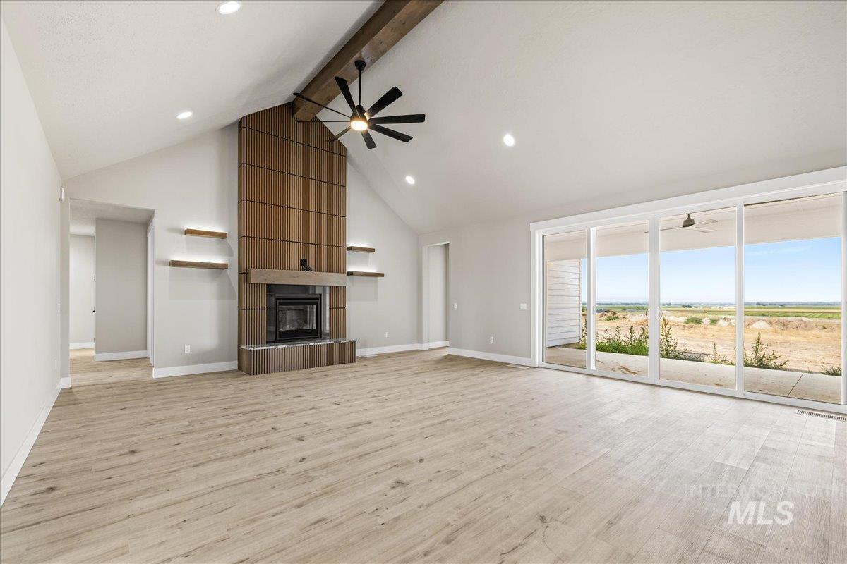 Unfurnished living room with beamed ceiling, high vaulted ceiling, light wood-style flooring, ceiling fan, and recessed lighting