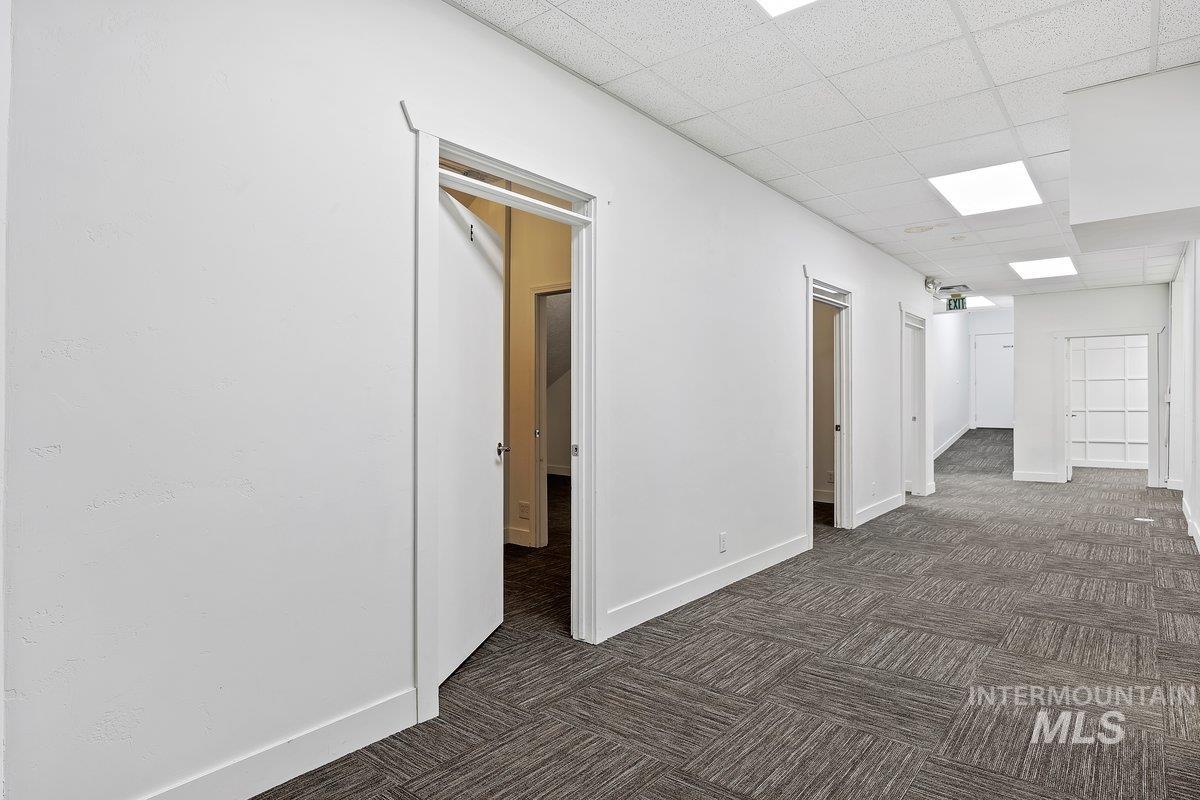 Unfurnished room with dark colored carpet and a paneled ceiling