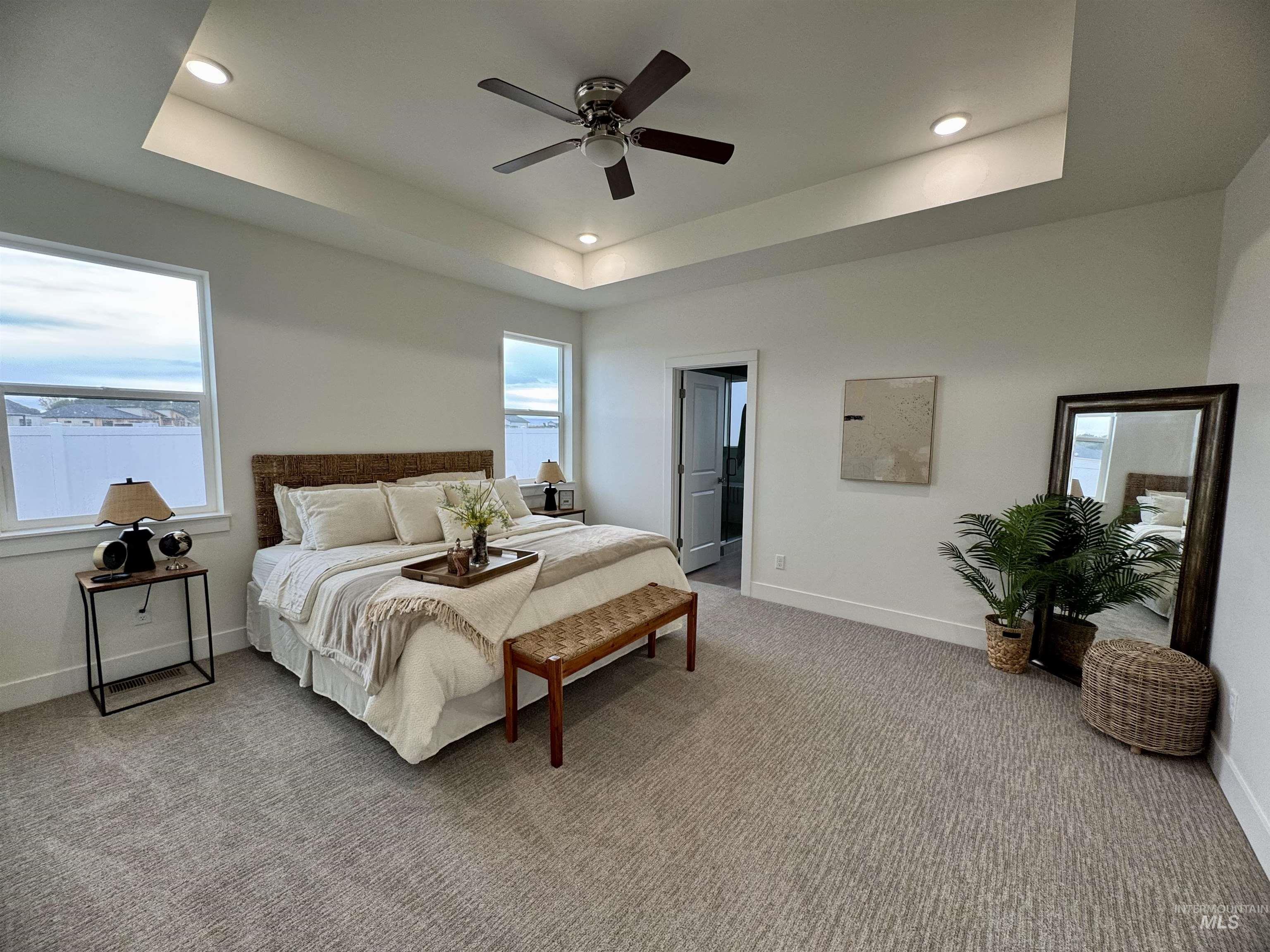 Bedroom with carpet floors, a tray ceiling, a ceiling fan, and recessed lighting