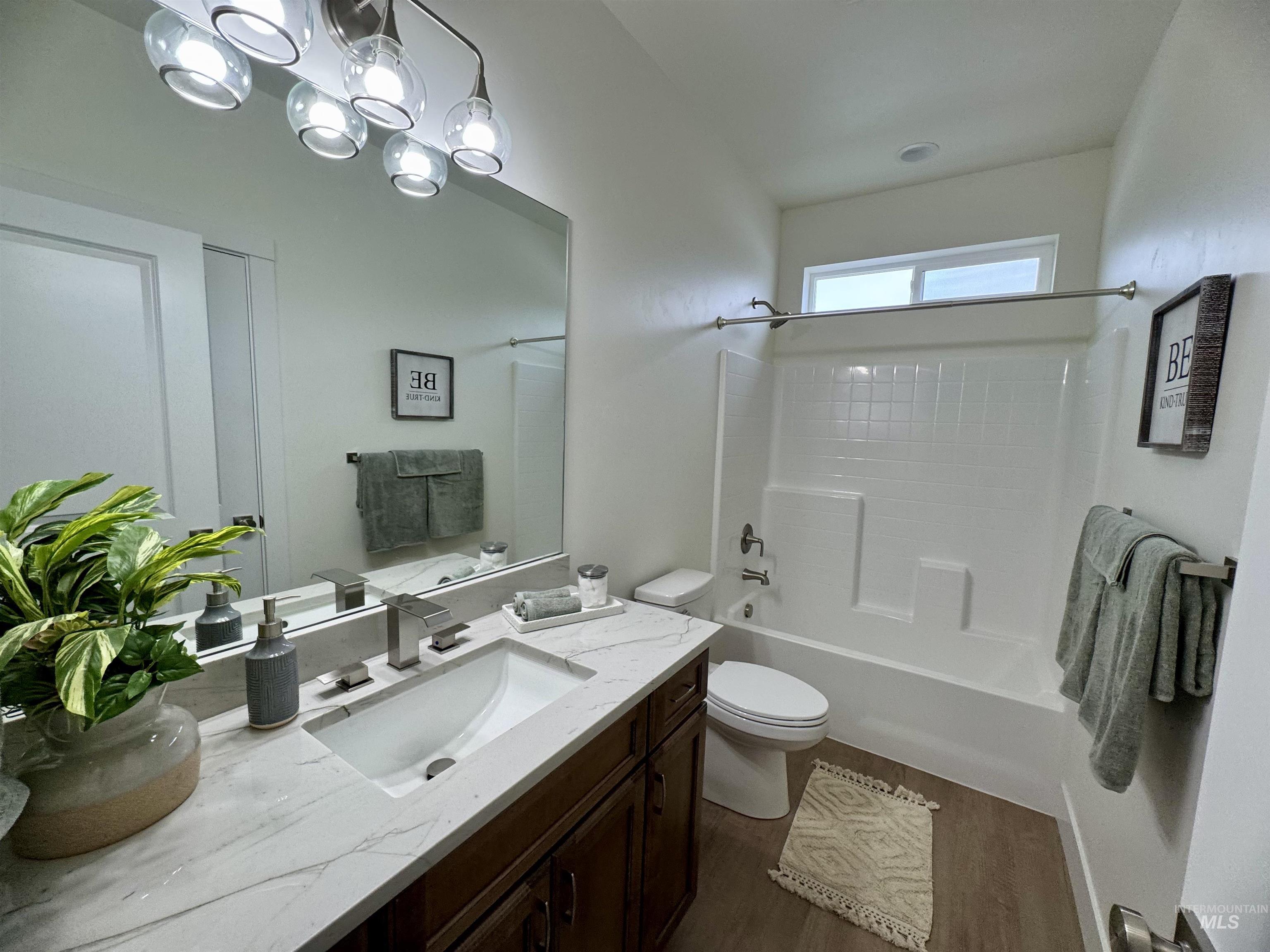 Full bathroom with dark wood-style flooring, vanity, and shower / bath combination