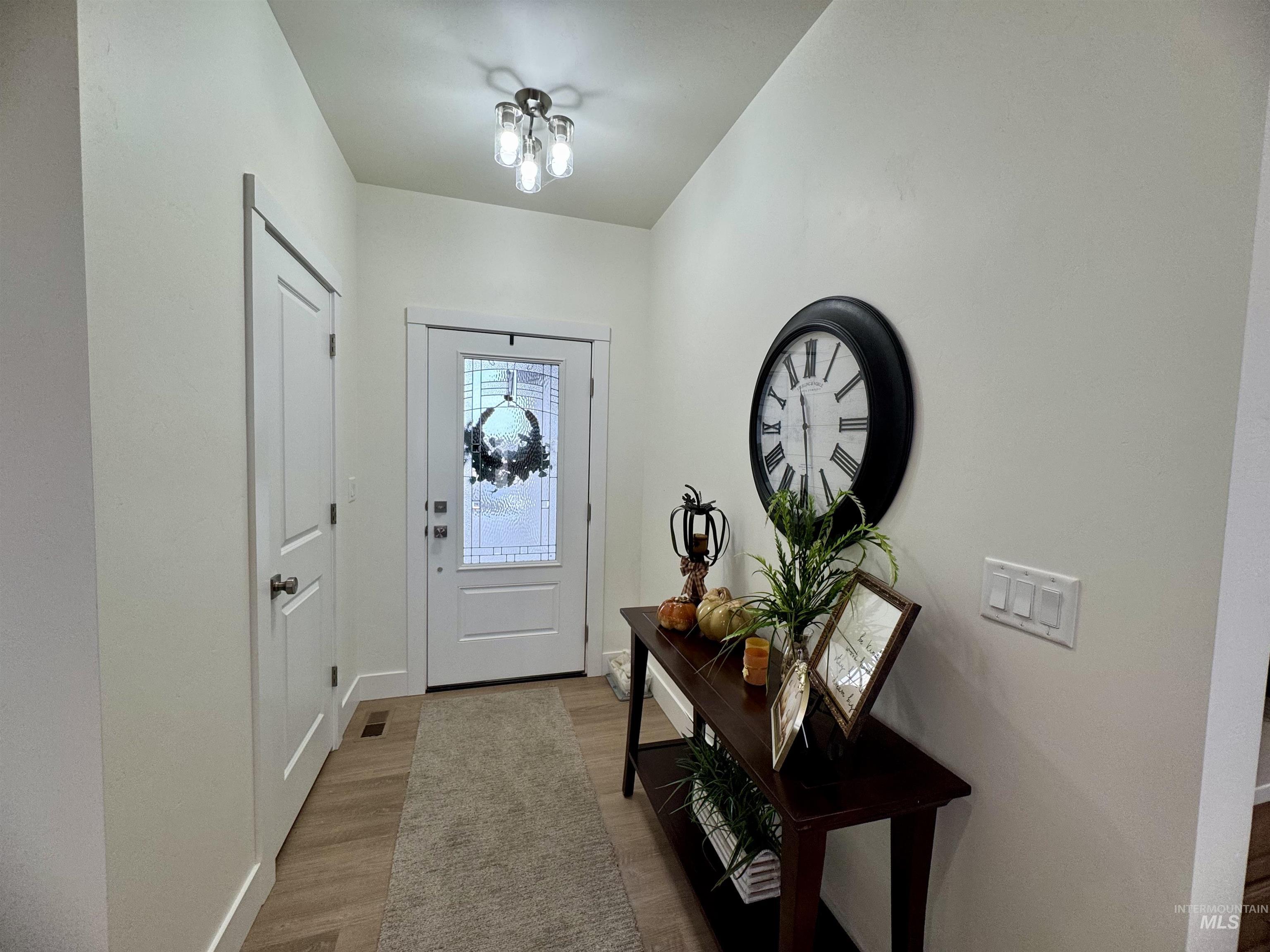 Foyer featuring light wood-style flooring and baseboards