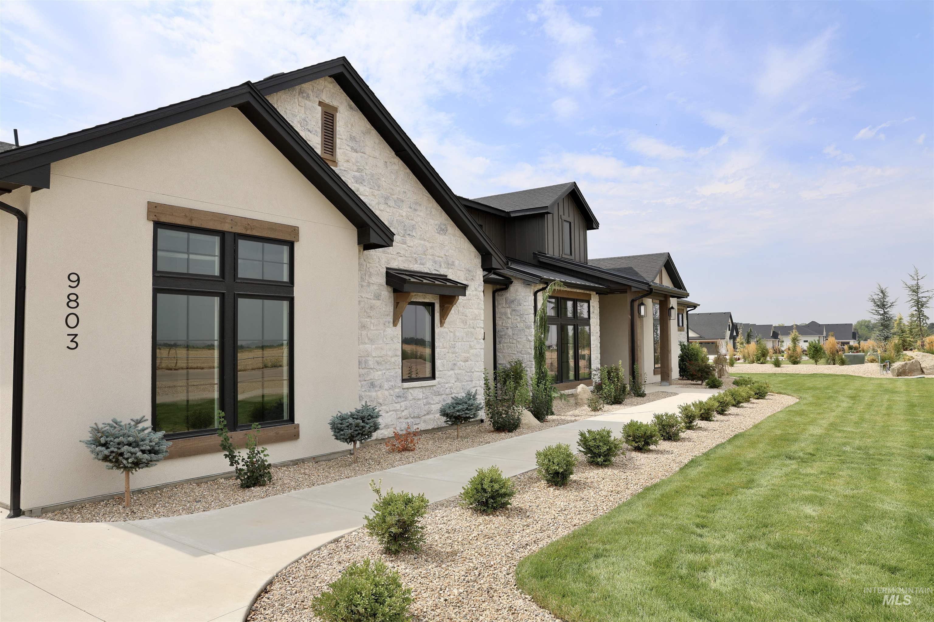 View of side of property featuring stone siding, a lawn, and a porch