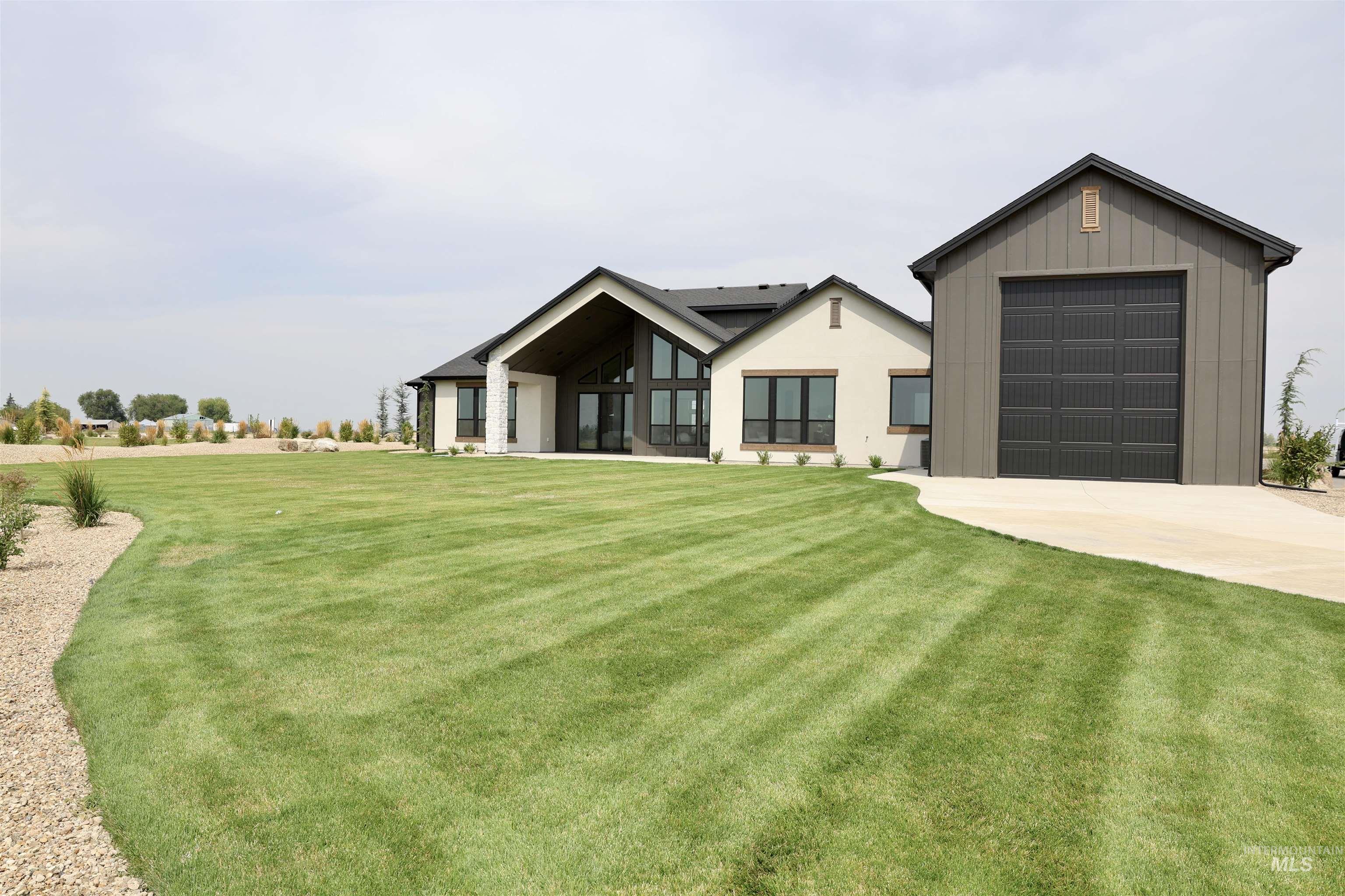 View of front of house featuring concrete driveway, a front yard, and board and batten siding