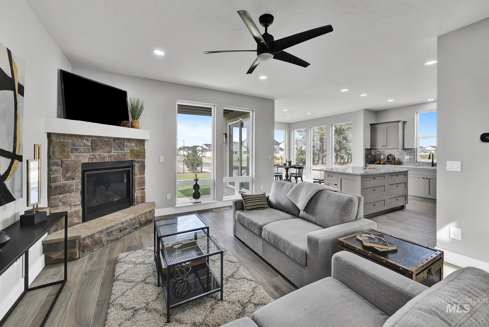 Living room featuring a fireplace, plenty of natural light, dark wood finished floors, recessed lighting, and ceiling fan
