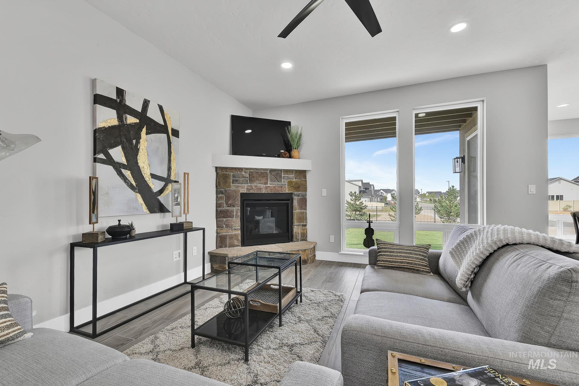 Living area with a fireplace, wood finished floors, recessed lighting, and ceiling fan