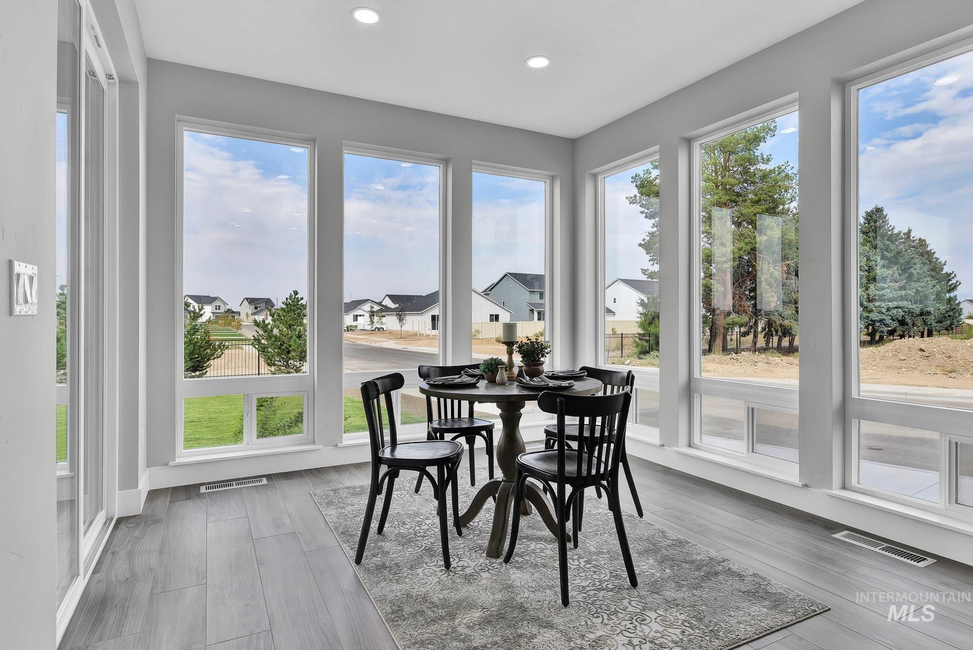 Sunroom featuring wood finished floors, a residential view, and recessed lighting