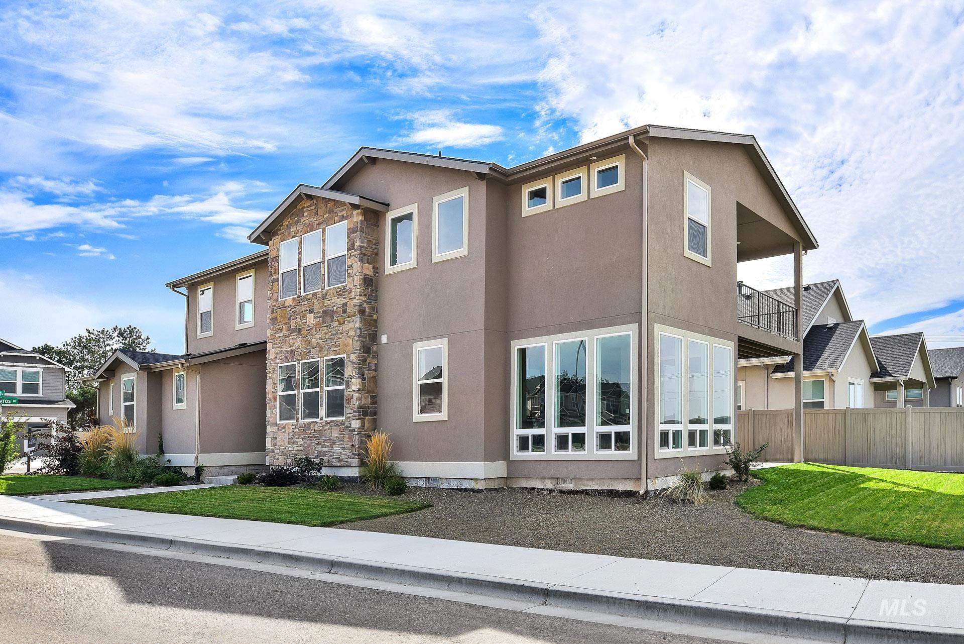 View of property exterior with a balcony, stone siding, stucco siding, and a residential view