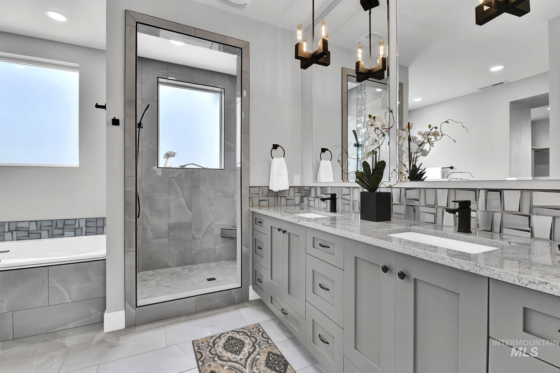 Full bath featuring a garden tub, double vanity, a stall shower, recessed lighting, and healthy amount of natural light