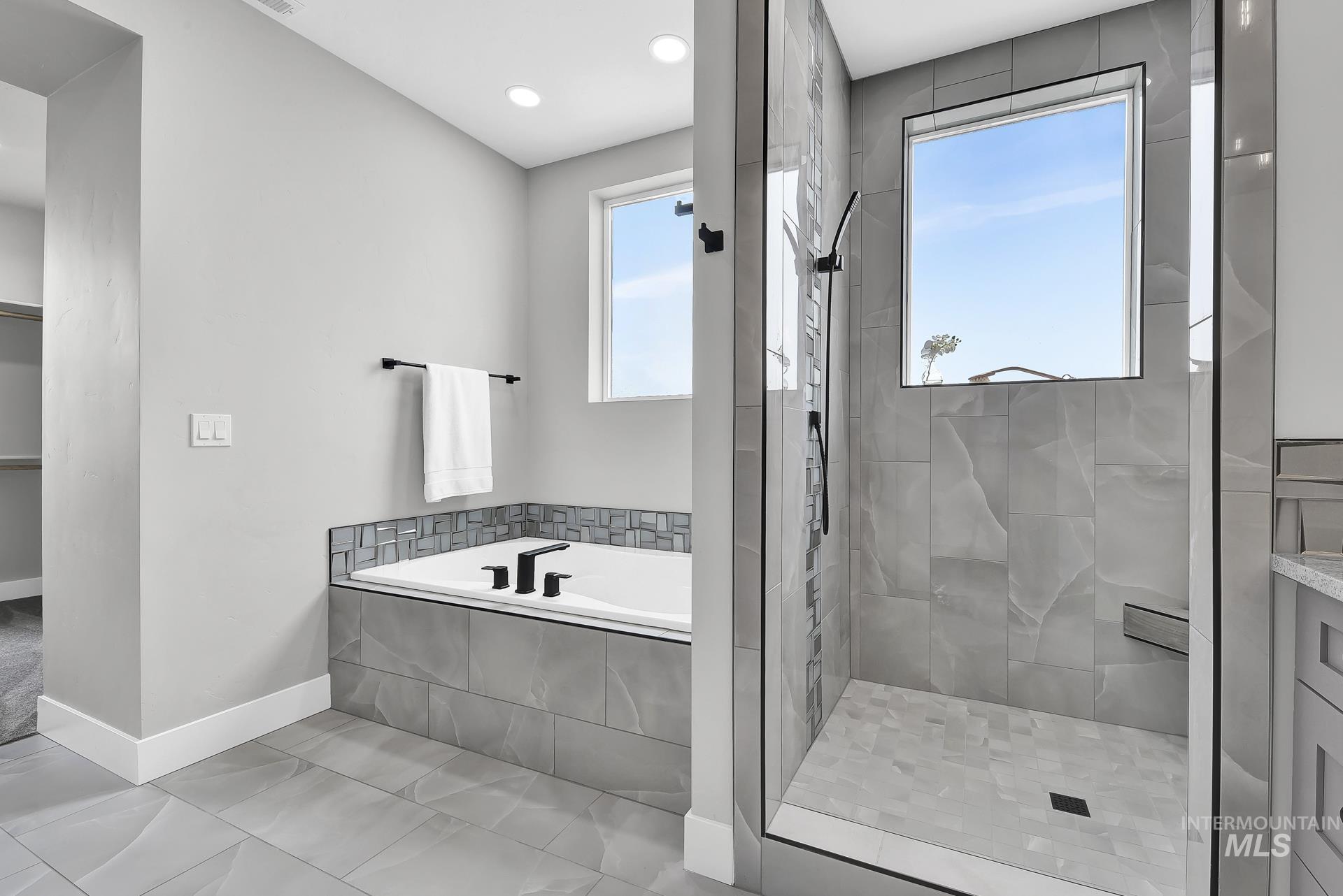 Full bath with a bath, a stall shower, and a closet