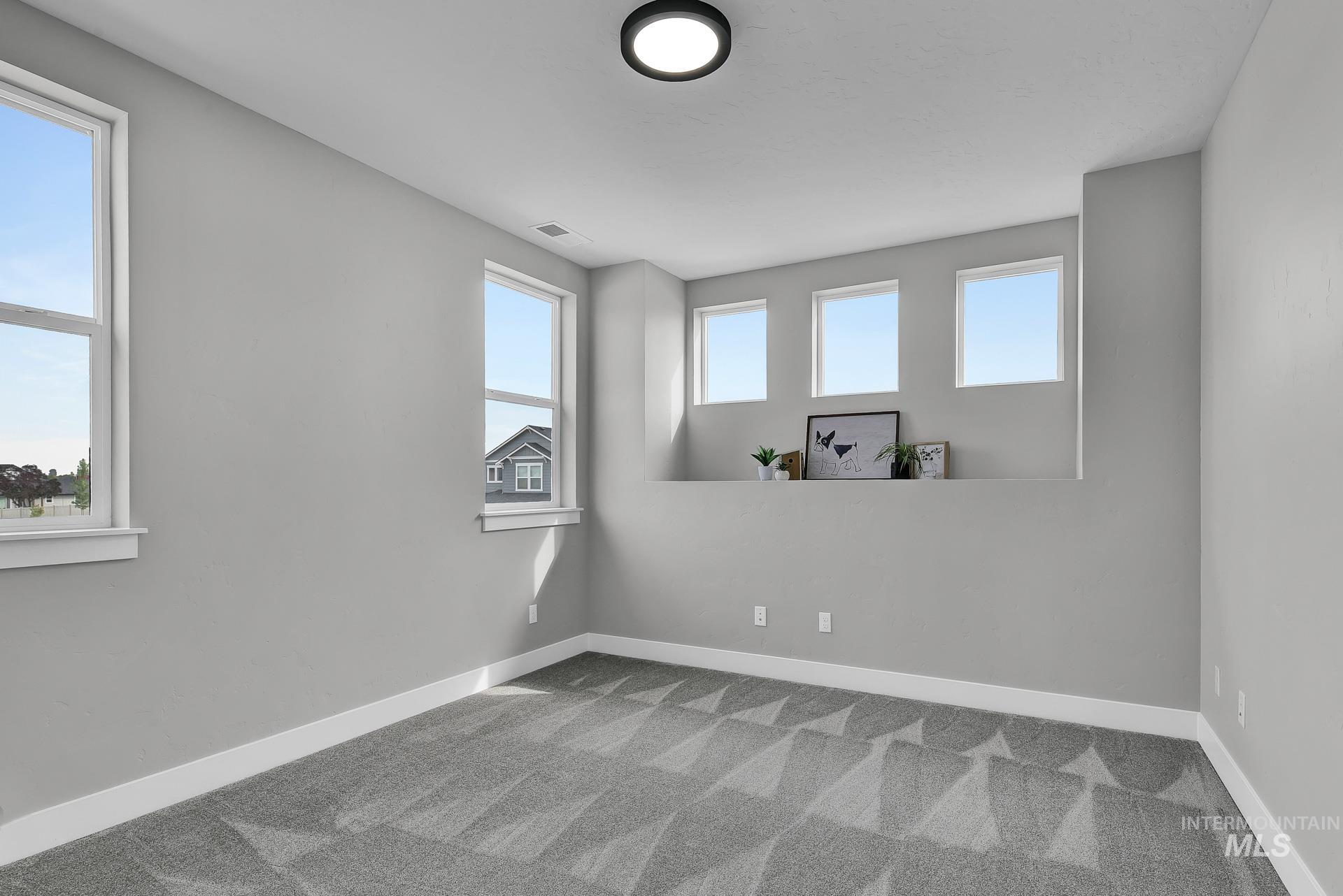 Carpeted empty room with healthy amount of natural light