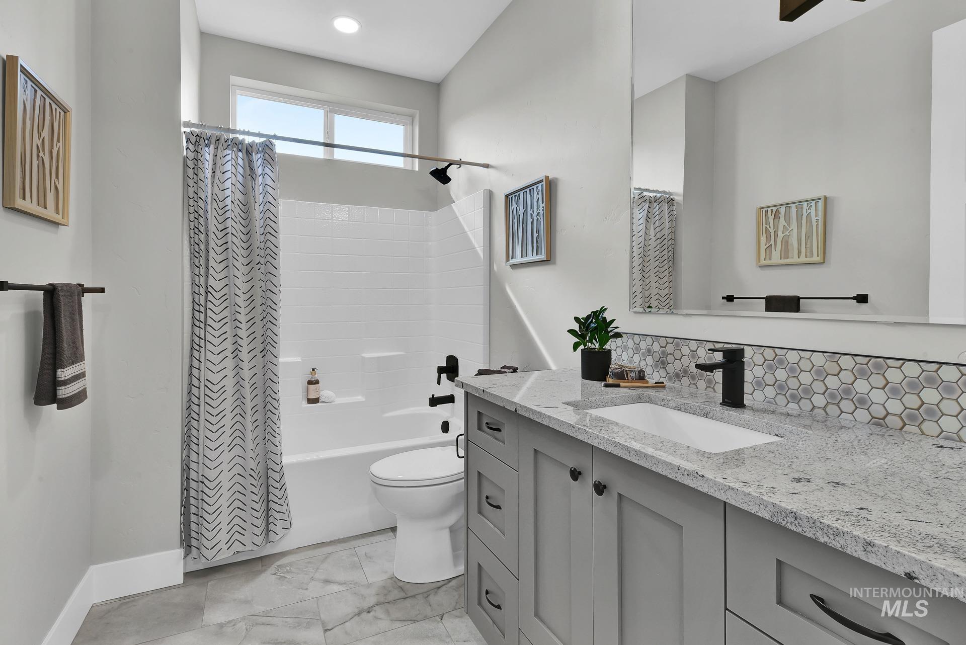 Bathroom with shower / tub combo with curtain, vanity, and tasteful backsplash