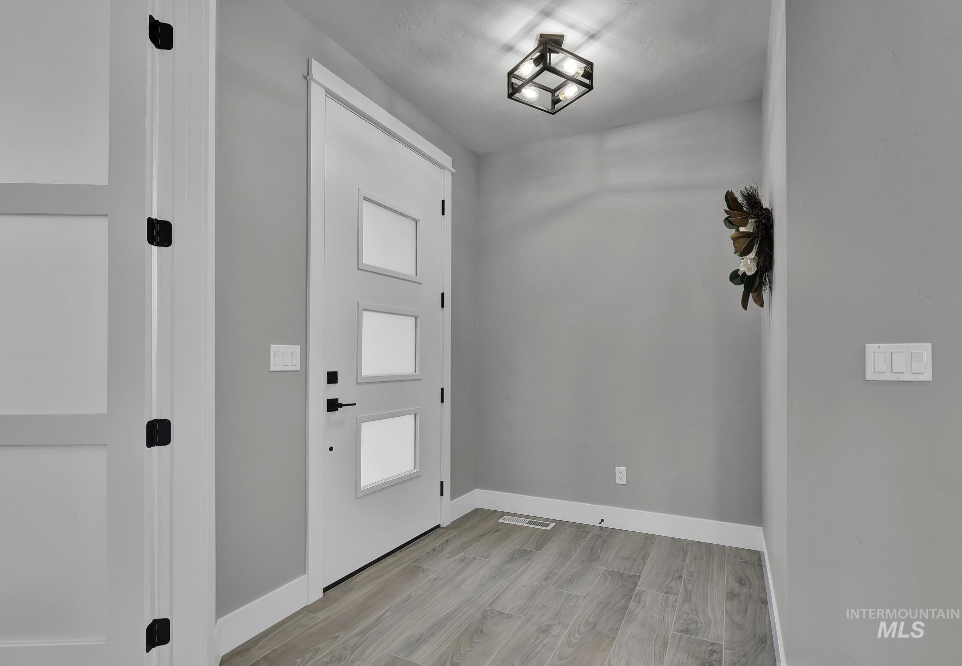 Entryway with light wood finished floors and baseboards