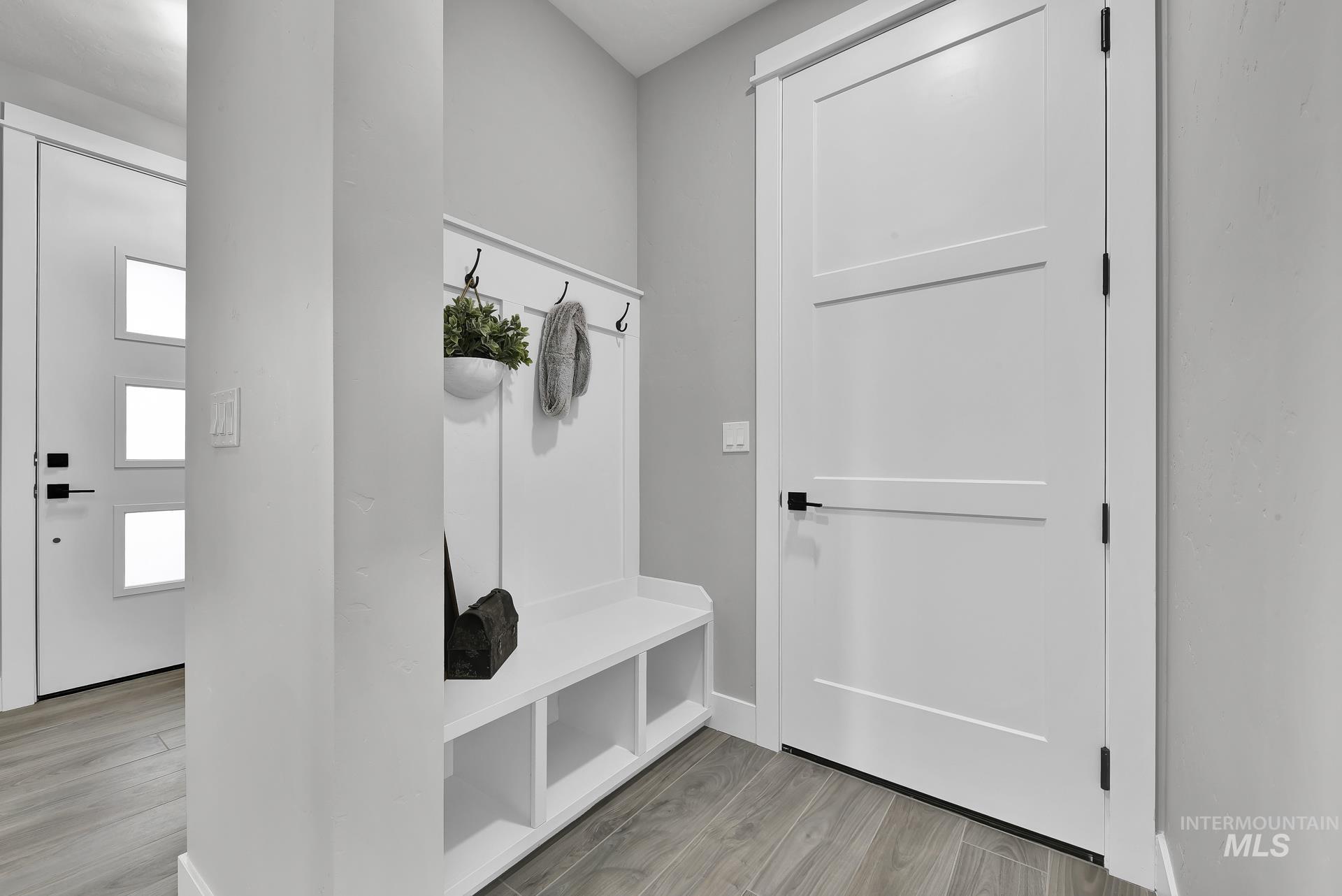 Mudroom featuring light wood finished floors and baseboards