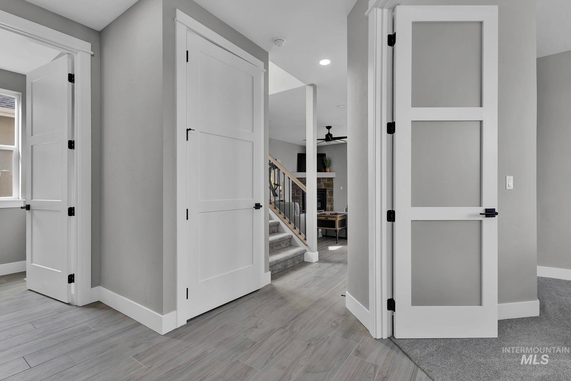 Corridor featuring stairs, light wood-type flooring, and recessed lighting
