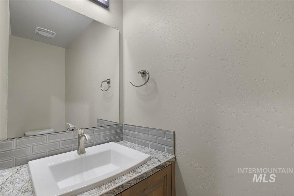 Bathroom with vanity and tasteful backsplash