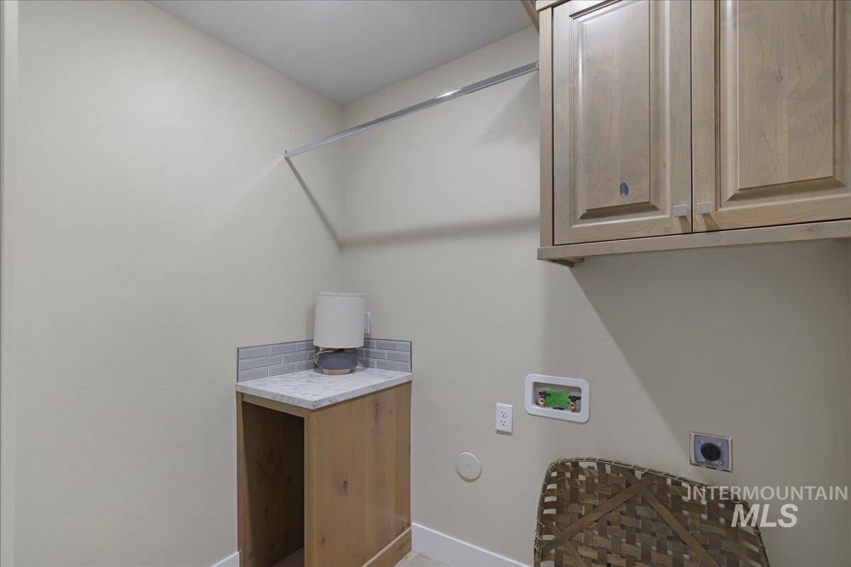 Laundry room featuring electric dryer hookup, cabinet space, and washer hookup