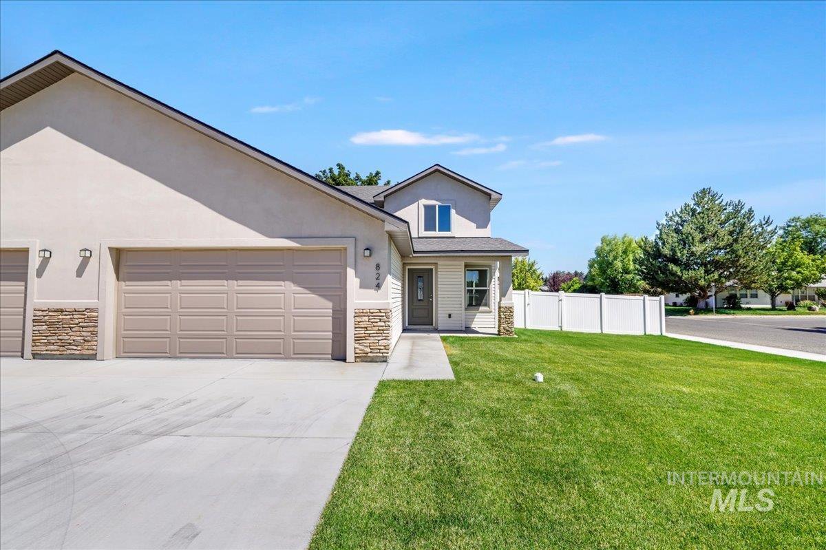 View of front of home featuring stone siding, an attached garage, stucco siding, and driveway