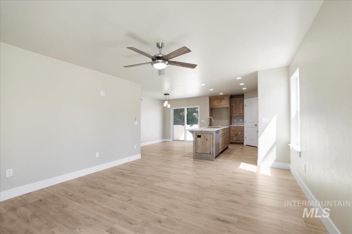 Unfurnished living room with ceiling fan, light wood finished floors, and recessed lighting