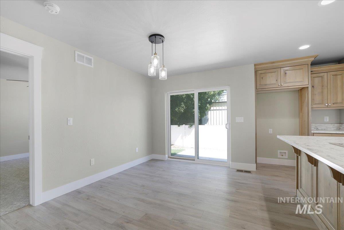Unfurnished dining area featuring light wood-type flooring and recessed lighting