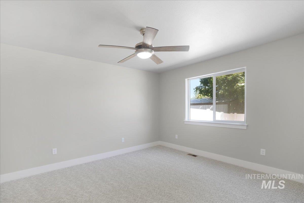 Unfurnished room with a ceiling fan and light carpet