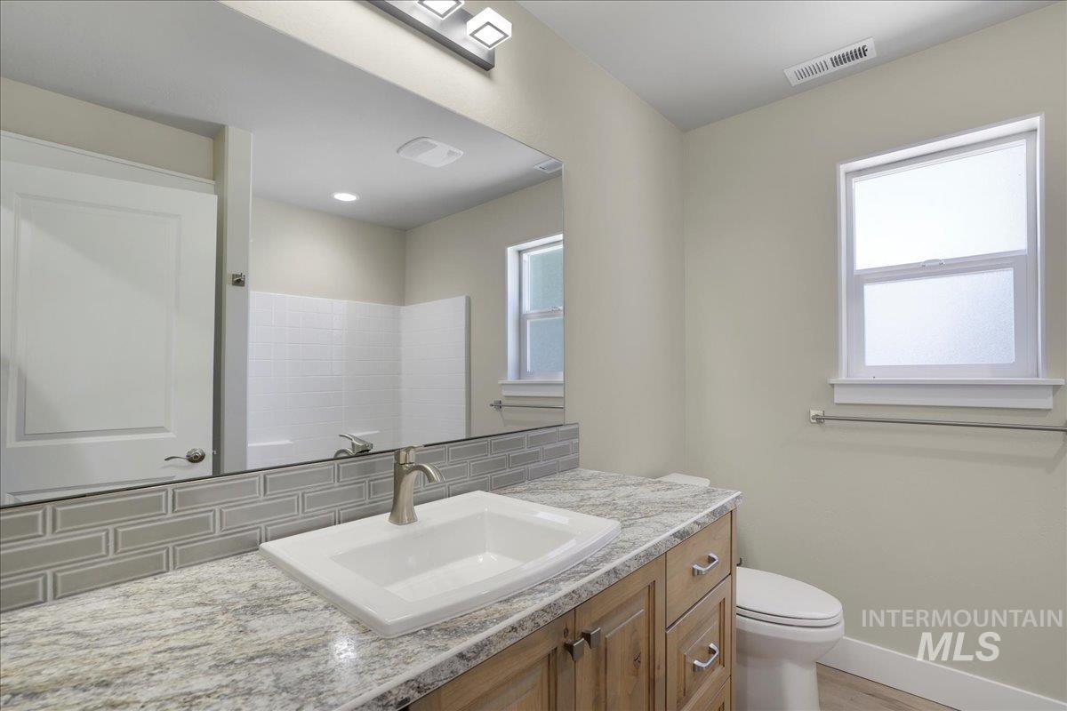 Bathroom with vanity, tasteful backsplash, and wood finished floors