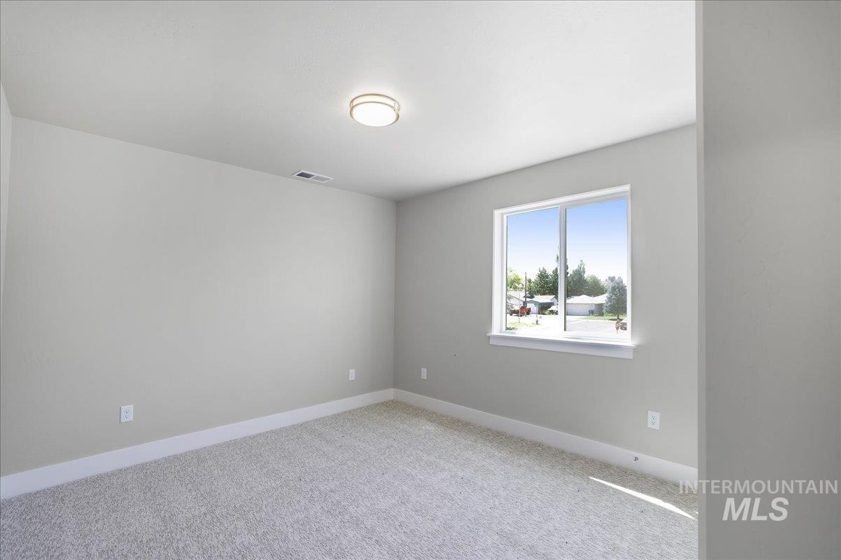 Spare room featuring carpet floors and baseboards