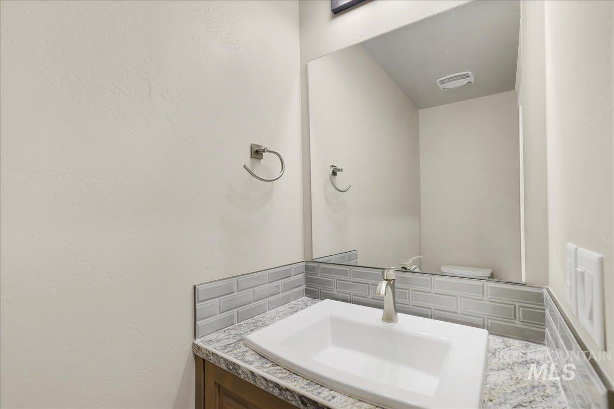 Bathroom featuring vanity and backsplash