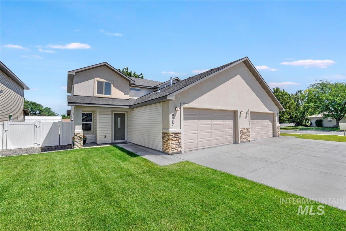 View of front facade featuring a gate, a garage, stucco siding, driveway, and roof with shingles