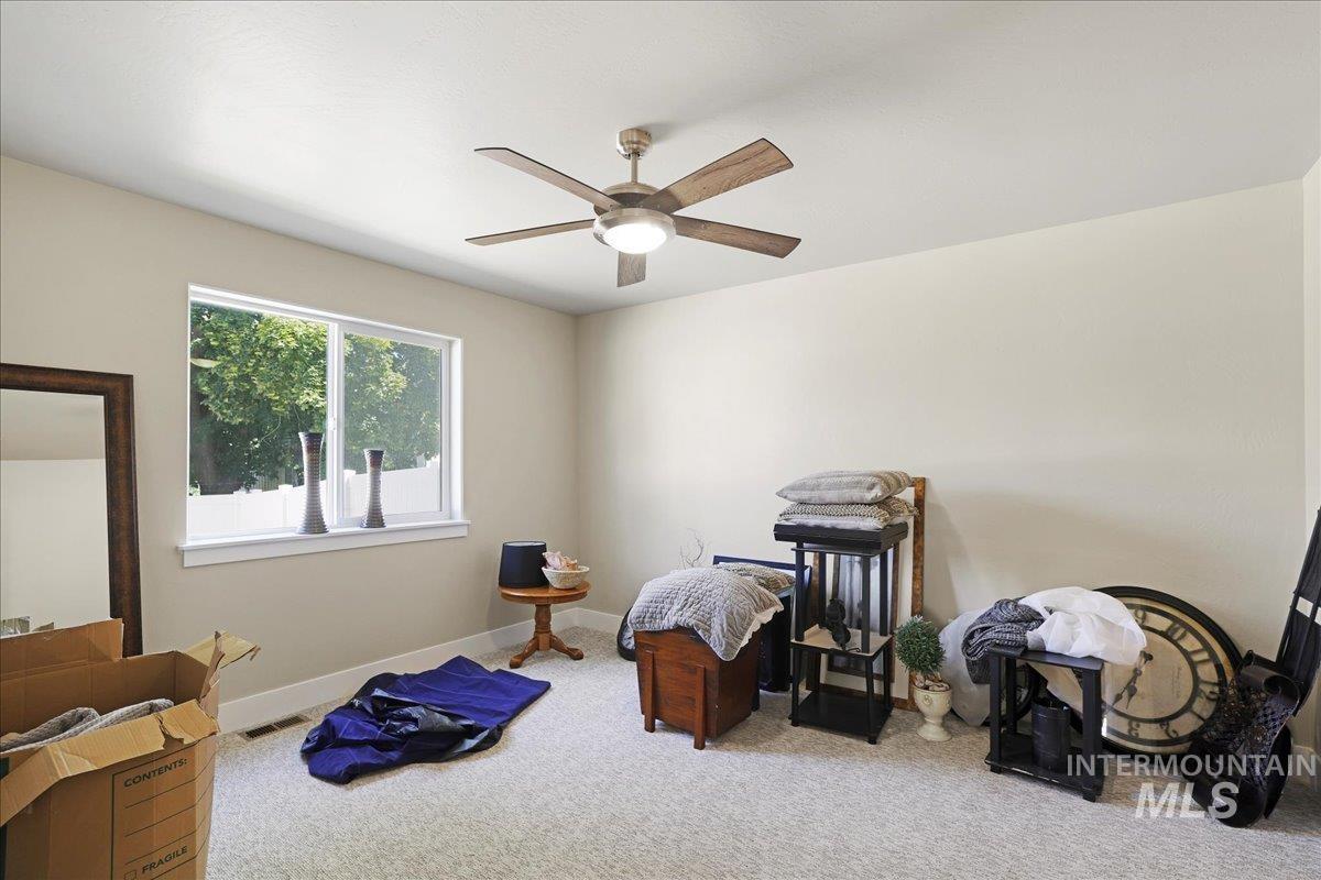 Carpeted bedroom with baseboards and a ceiling fan
