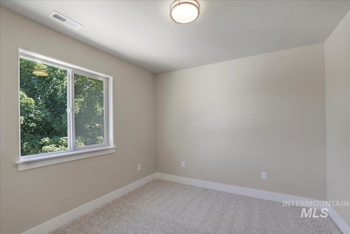 Spare room with baseboards and light colored carpet
