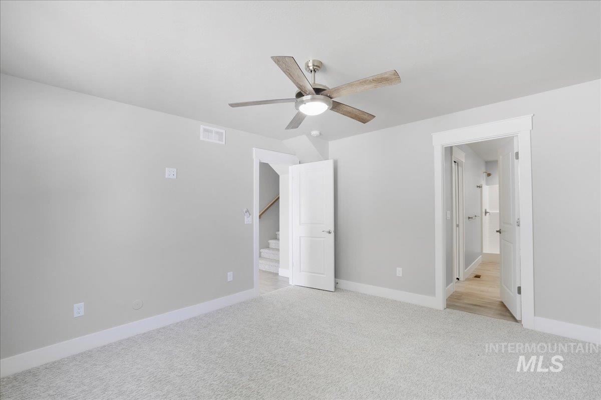 Unfurnished bedroom featuring light carpet and a ceiling fan