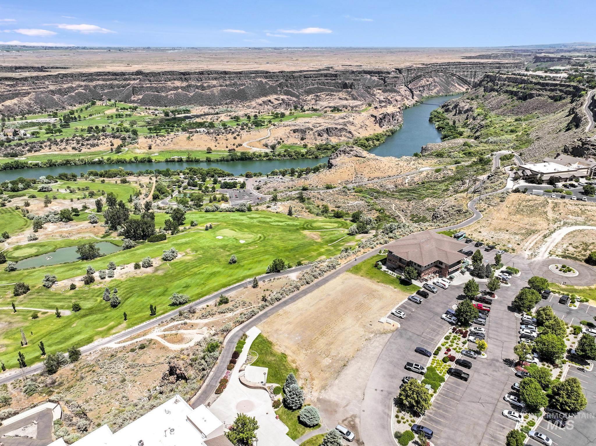 Aerial view of property and surrounding area with a nearby body of water and a golf course
