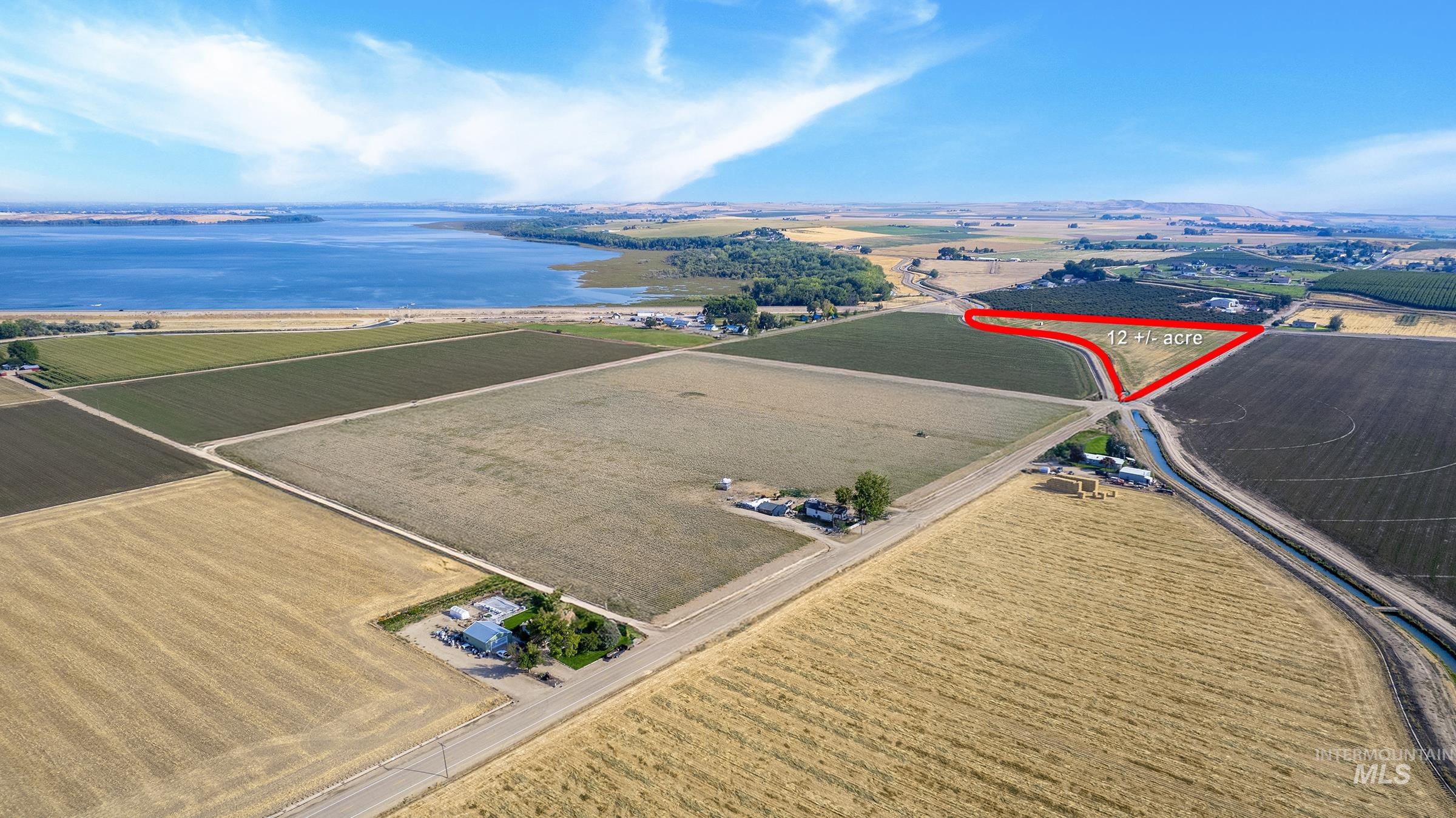 View of rural area featuring a large body of water, farmland, and property parcel outlined