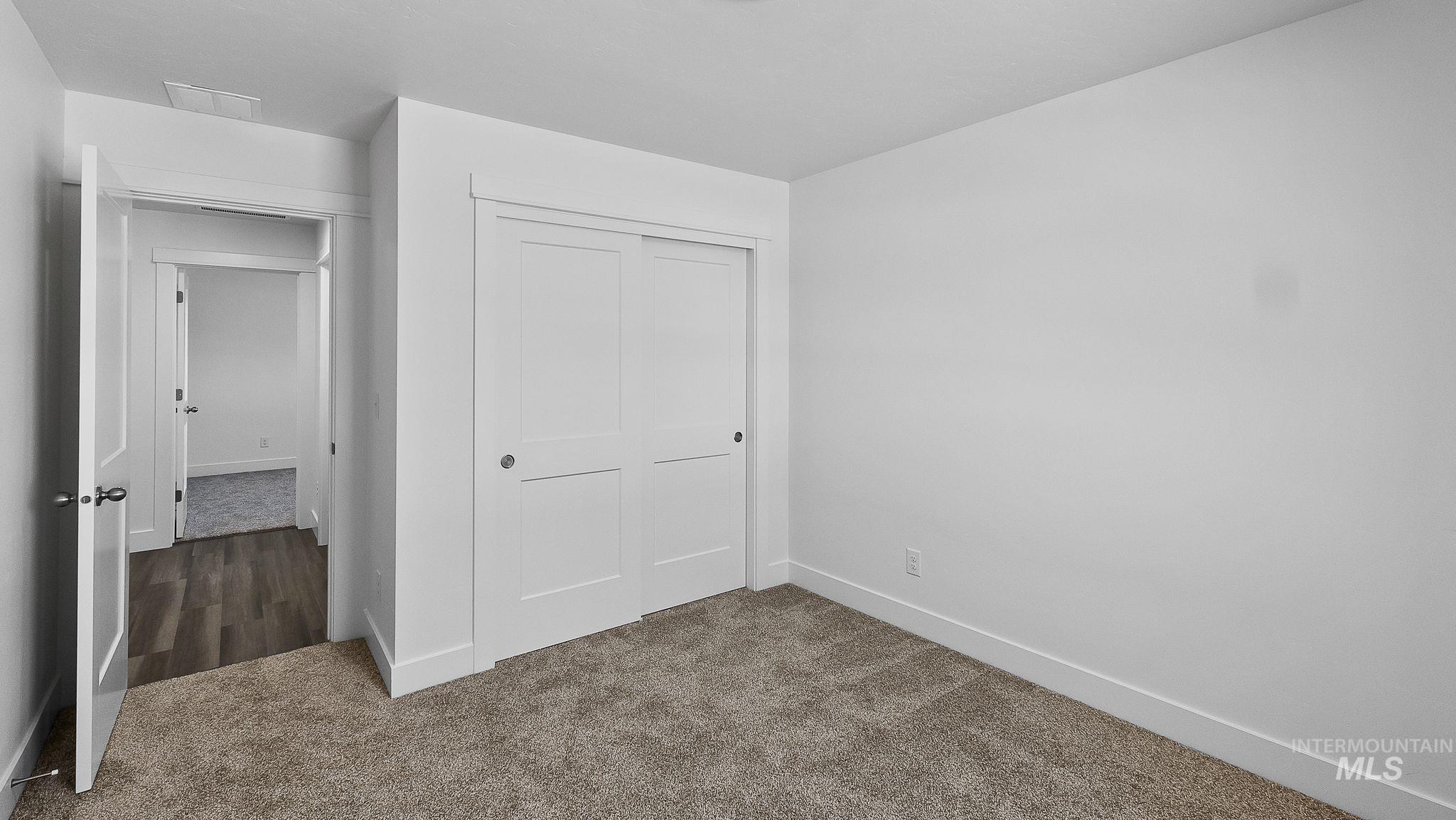 Unfurnished bedroom featuring carpet and a closet