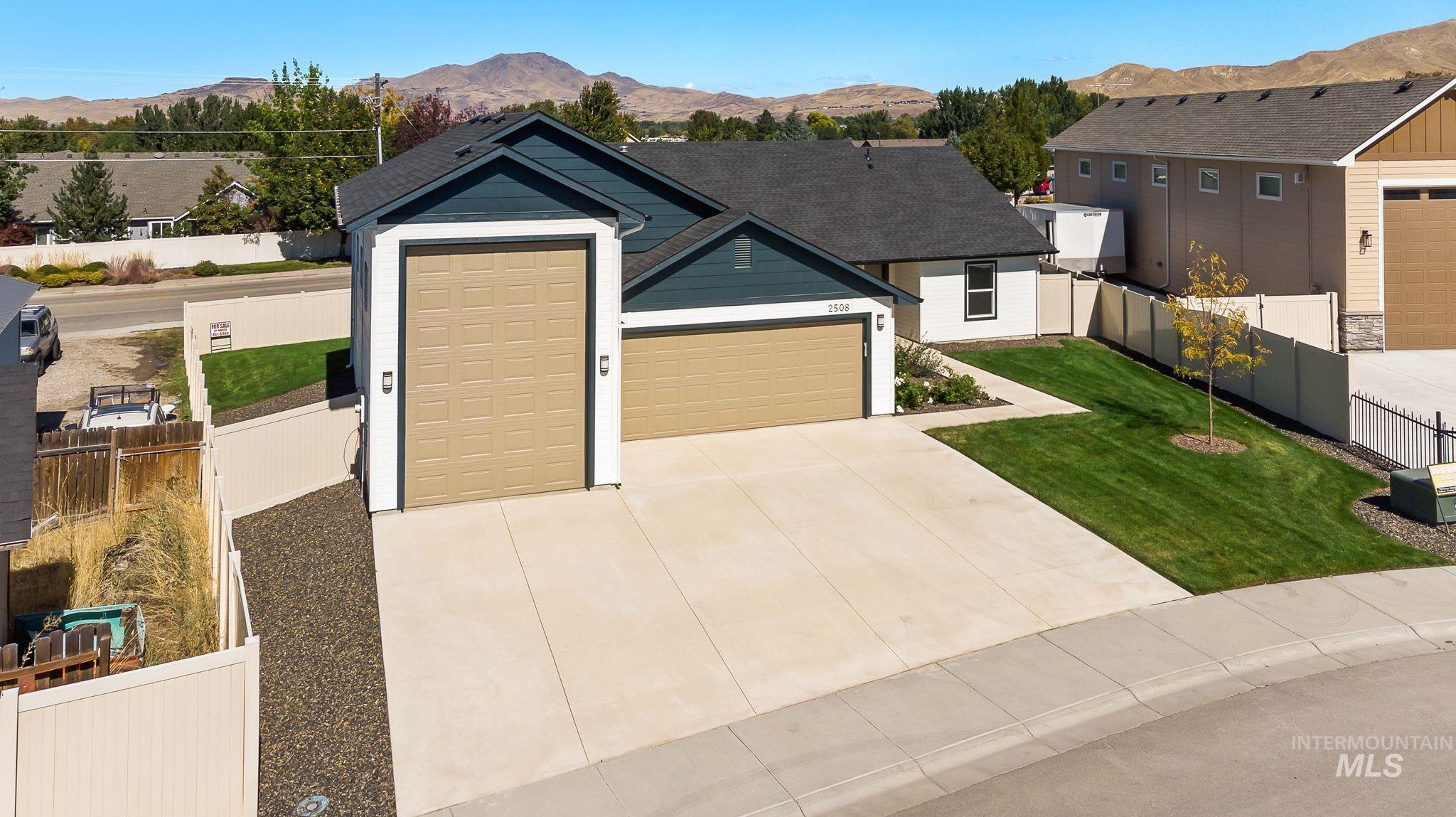 Ranch-style house featuring a mountain view, concrete driveway, a residential view, and an attached garage