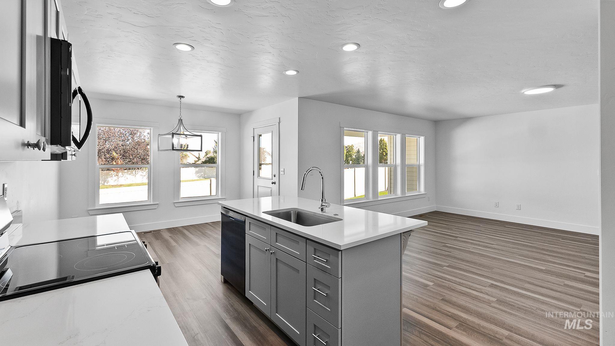 Kitchen with gray cabinetry, black appliances, dark wood-type flooring, decorative light fixtures, and recessed lighting