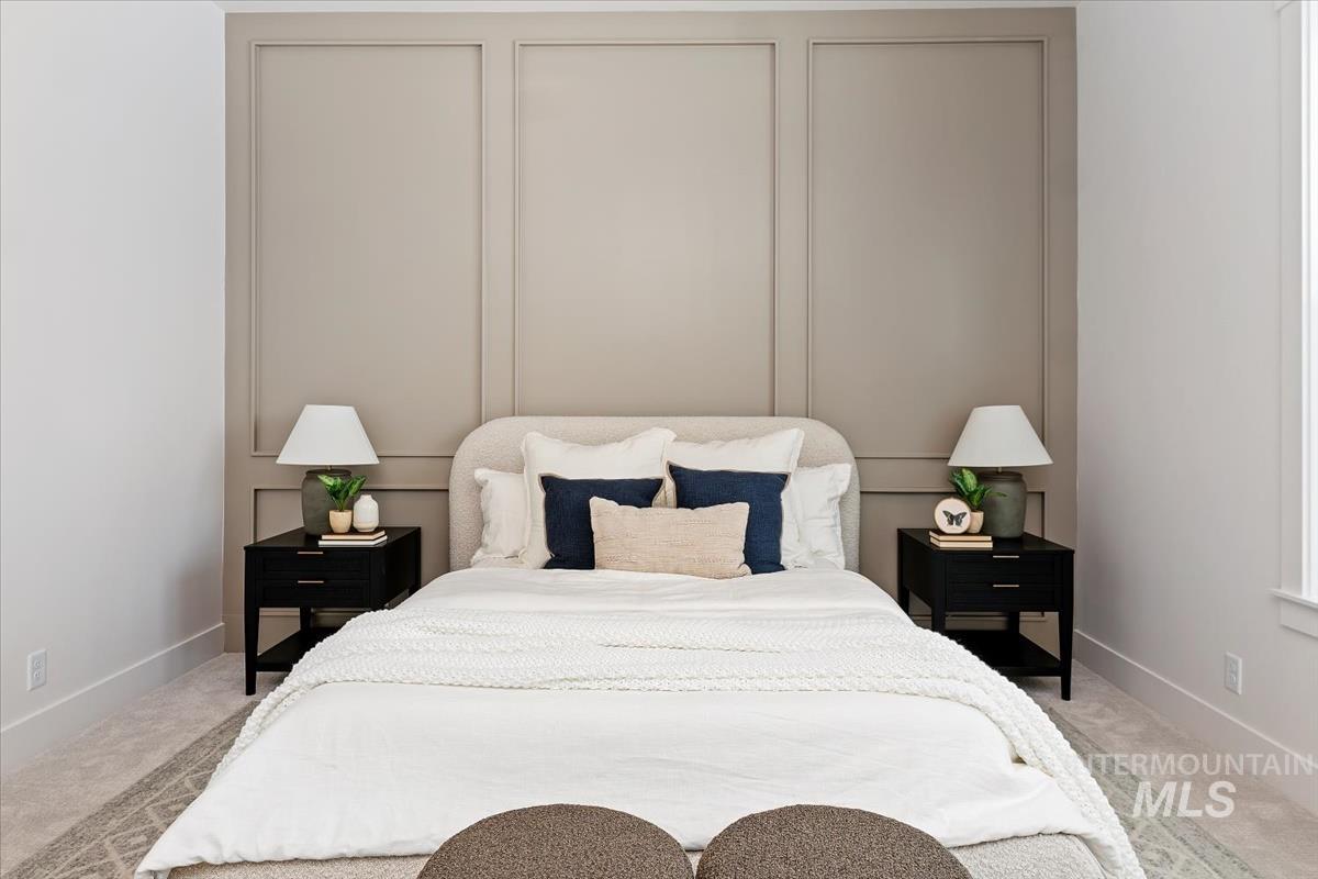 Bedroom featuring baseboards and light colored carpet