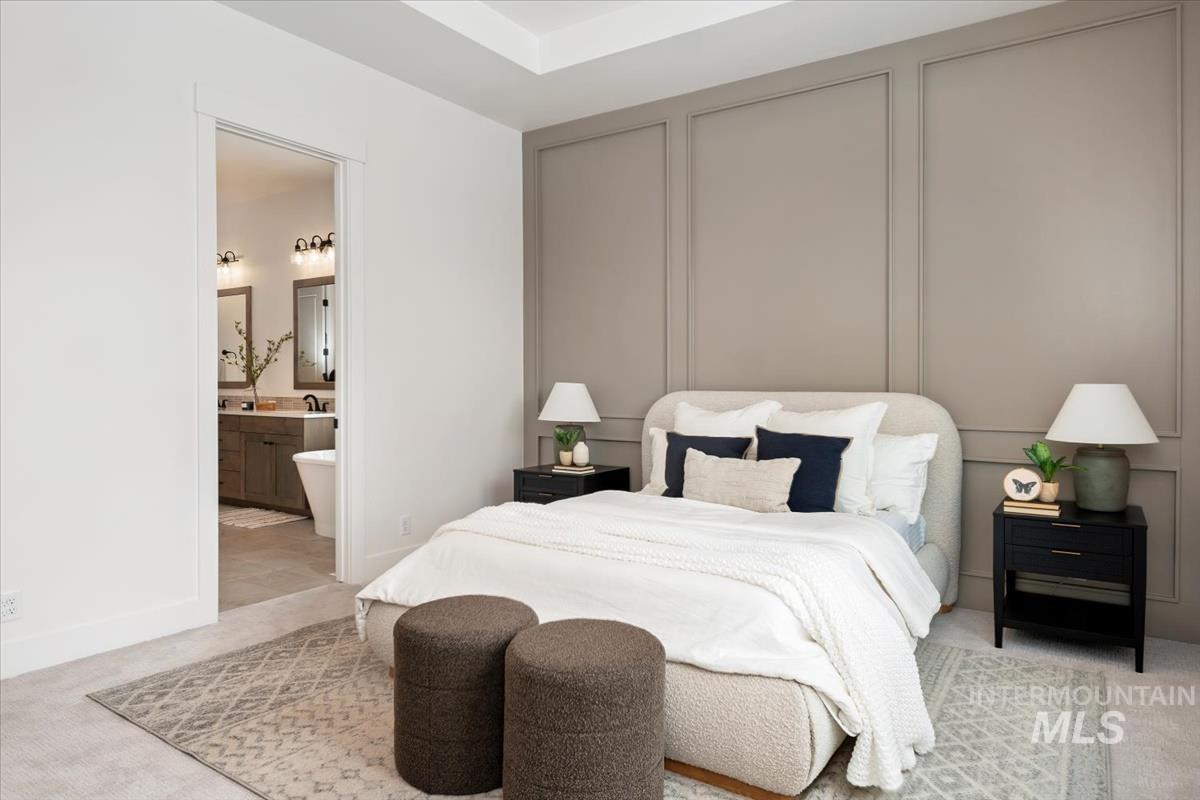 Bedroom featuring light carpet and connected bathroom