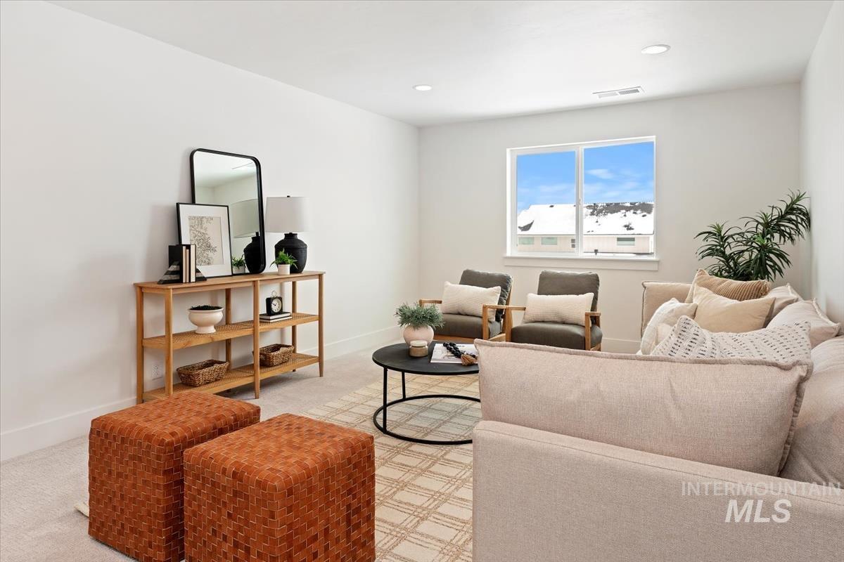 Living area featuring light colored carpet and recessed lighting