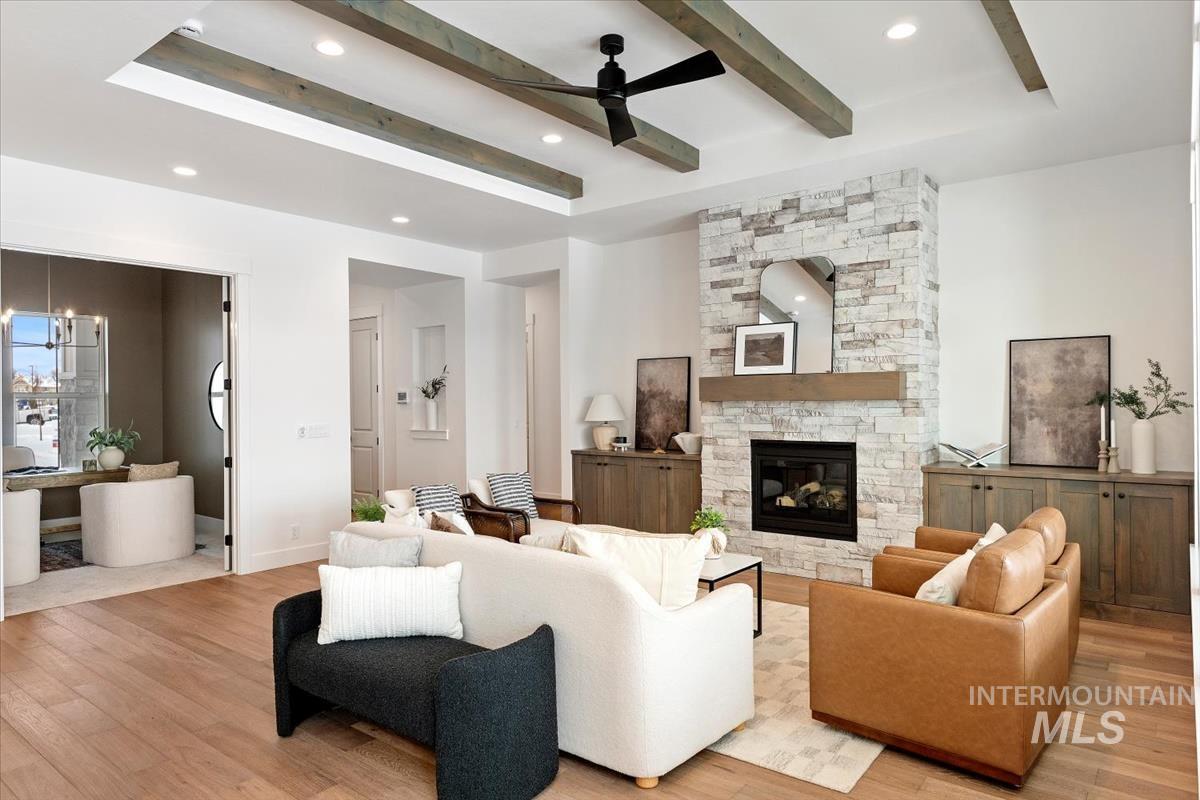 Living room featuring a ceiling fan, beamed ceiling, light wood-style floors, a chandelier, and recessed lighting