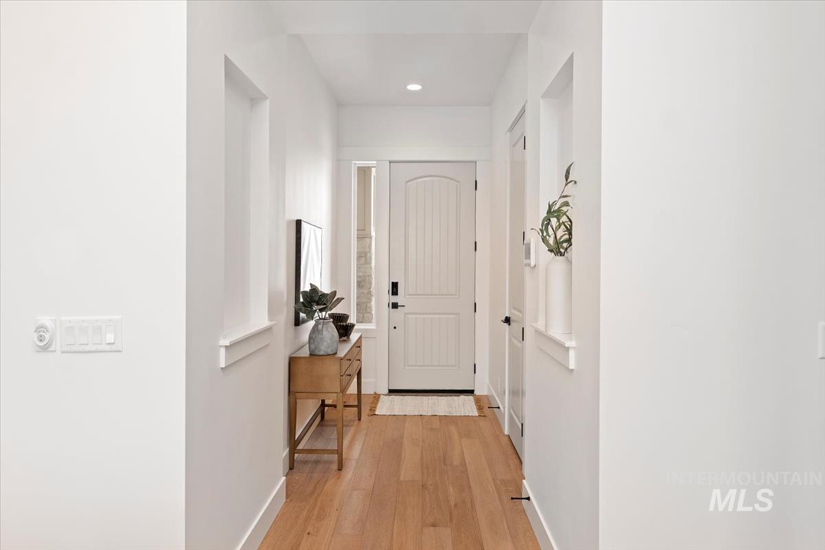 Corridor featuring light wood finished floors and recessed lighting