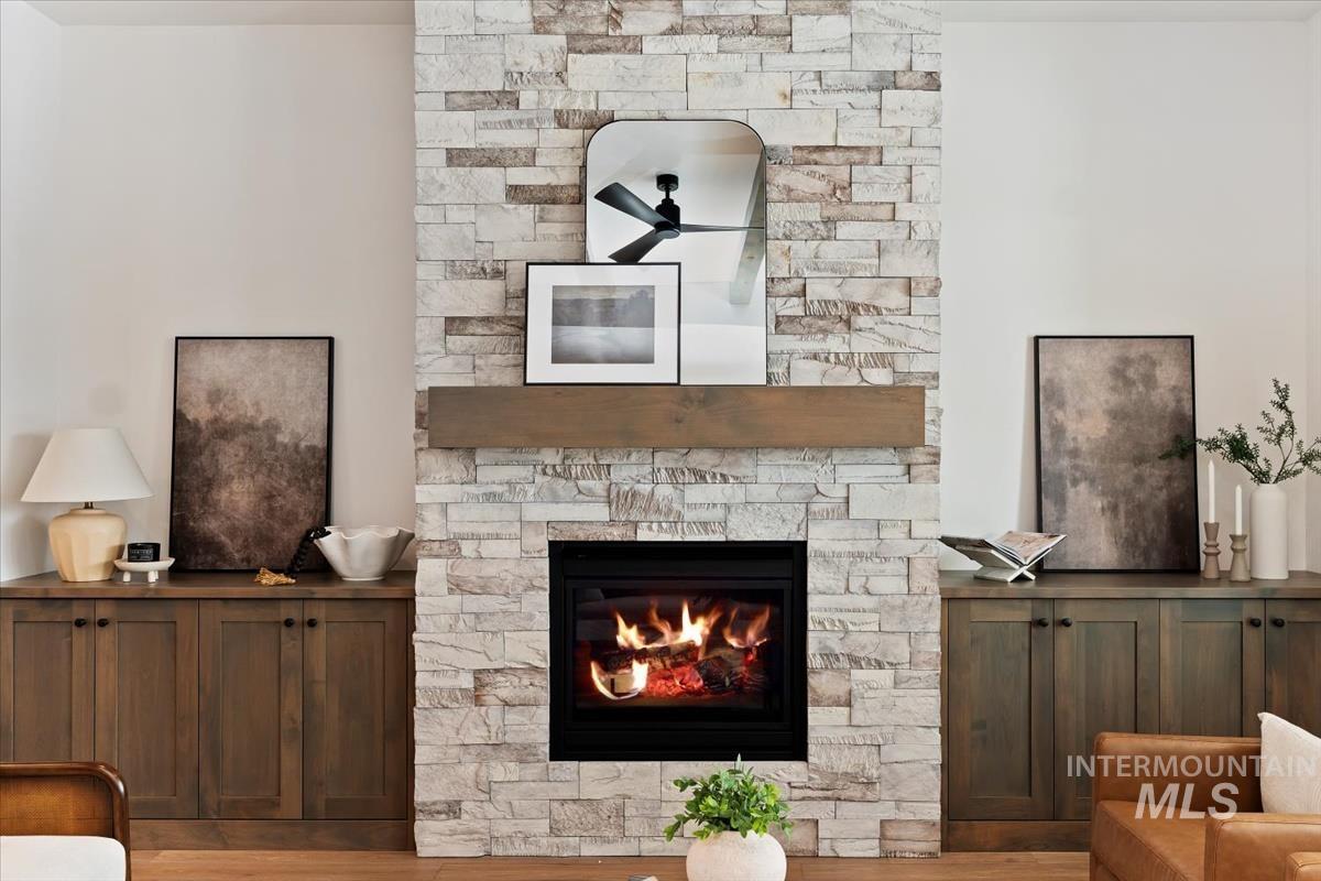 Living room featuring a stone fireplace and wood finished floors