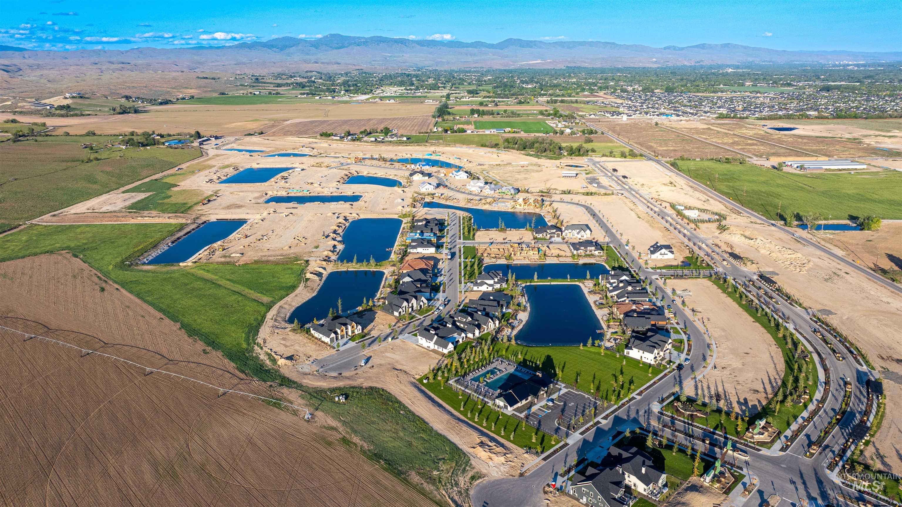 Aerial view of property and surrounding area featuring a water and mountain view
