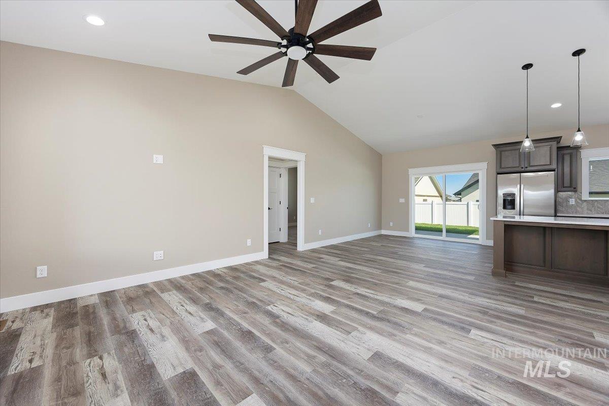 Unfurnished living room with recessed lighting, light wood-style floors, ceiling fan, and lofted ceiling