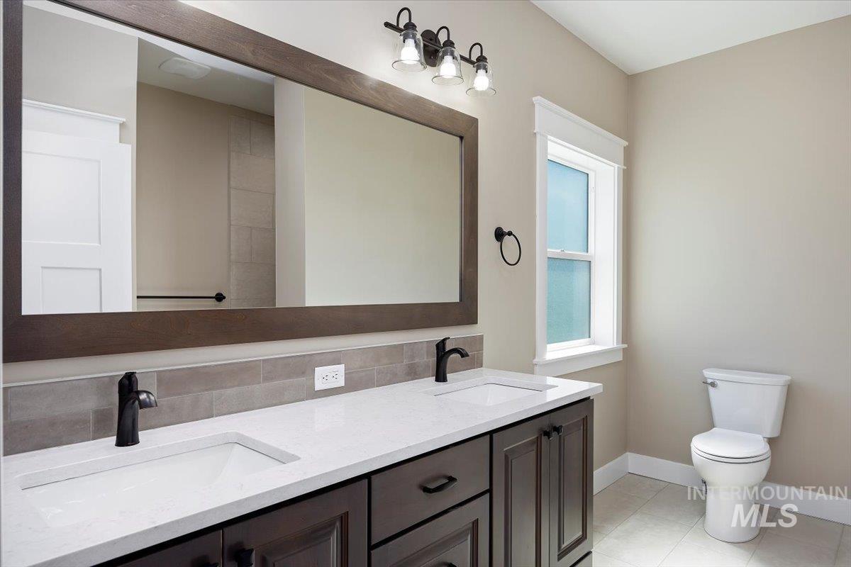 Full bathroom with backsplash and light tile patterned flooring