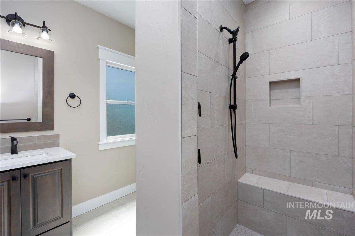 Bathroom featuring vanity, a stall shower, and light tile patterned floors