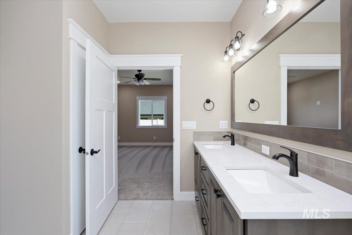 Full bath featuring light tile patterned floors, ceiling fan, and backsplash
