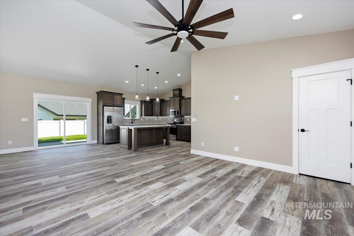 Unfurnished living room featuring recessed lighting, light wood-style flooring, a ceiling fan, and high vaulted ceiling
